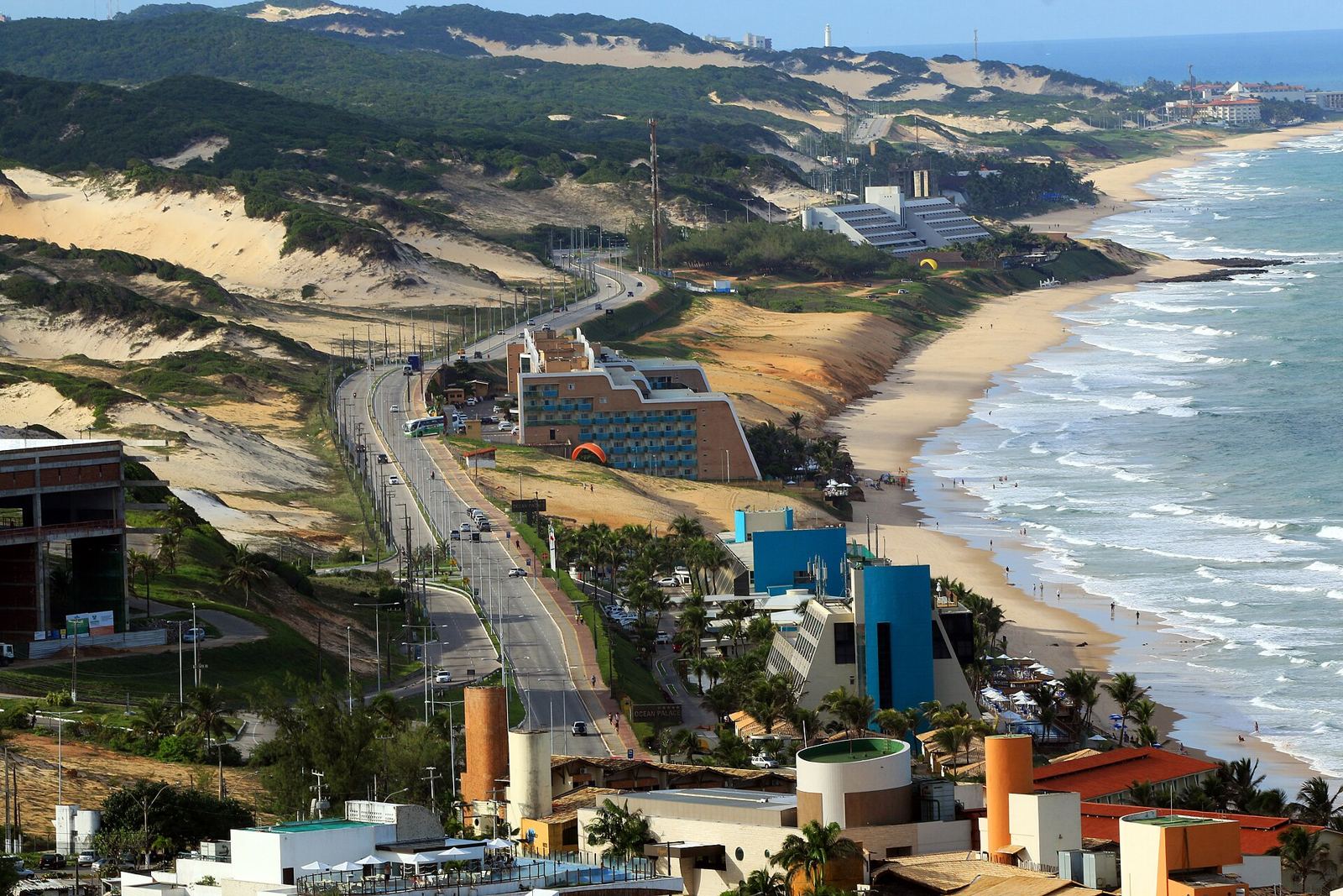 Vista aérea de Ponta Negra e da Via Costeira em Natal, com mar azul e dunas